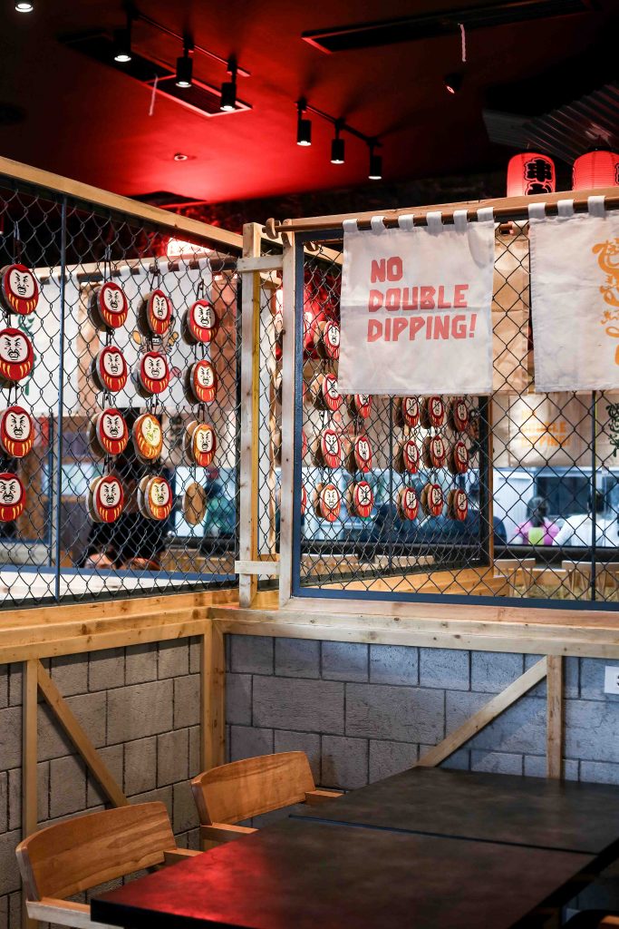 Kushikatsu Daruma’s interiors are reminiscent of Japan’s neon-lit streets, side by side with small temples bearing lucky daruma images, among other auspicious symbols.
