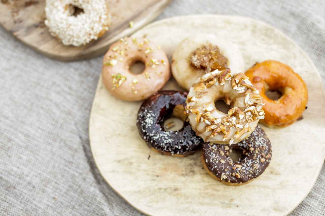 Plant-based restaurants in Manila: Green Bar has a lot of flavors for their vegan gourmet donuts. In photo: (Two at the top platter, left to right) crunchy peanut butter and raspberry vanilla. (Bottom platter, clockwise, from top left) Strawberry with pistachio, apple pie, goji, almond joy, blueberry coconut, and maple bacun. Photo by Danica Condez