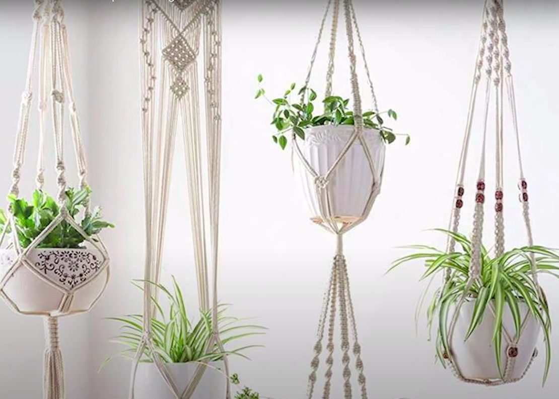 A photo of white macrame hanging planters with potted plant inside courtesy of Tatiana Cm on YouTube