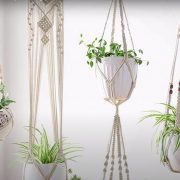 A photo of white macrame hanging planters with potted plant inside courtesy of Tatiana Cm on YouTube