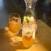 A photo of white wine sangria with apples, strawberry and lemons in a carafe and two glasses. Photo by Pauline Miranda for Nolisoli