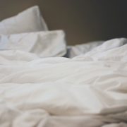 An unmade bed with white sheets