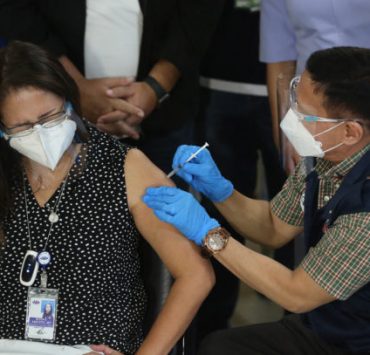 a woman injected covid-19 vaccine by a man