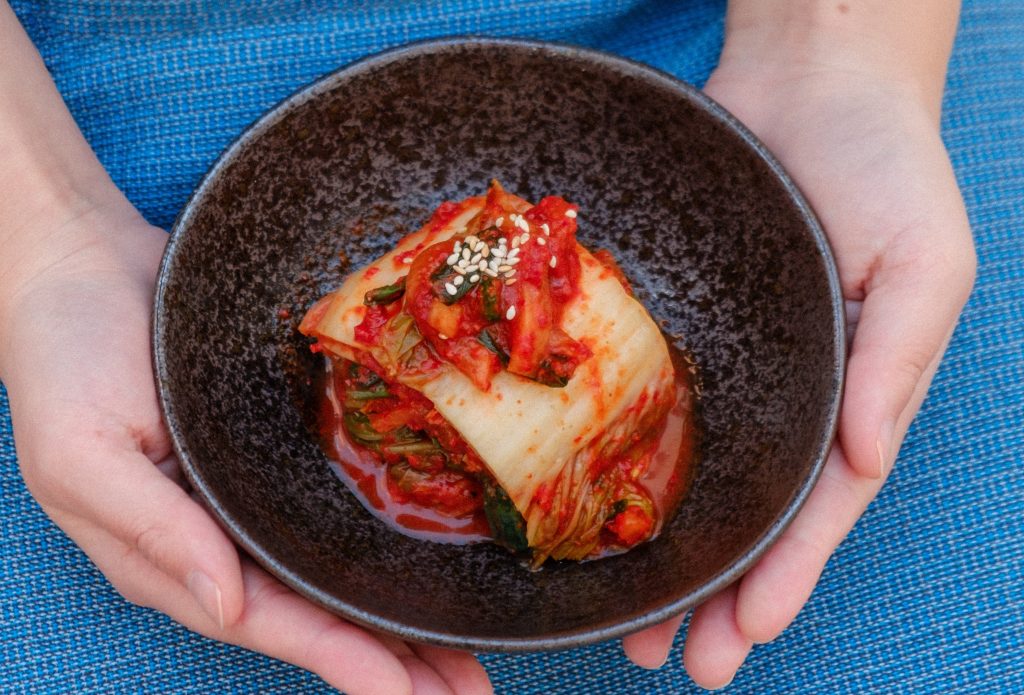 kimchi on a bowl held by two hands