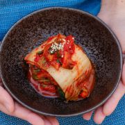 kimchi on a bowl held by two hands