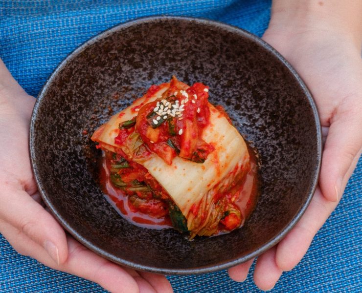 kimchi on a bowl held by two hands