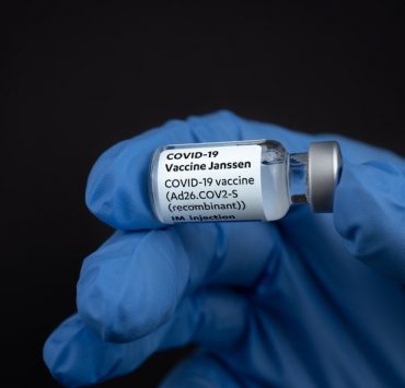 johnson&johnson janssen covid-19 vaccine vial held by a gloved hand