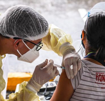 a medical worker injects a woman with covid-19 vaccine in novaliches quezon city