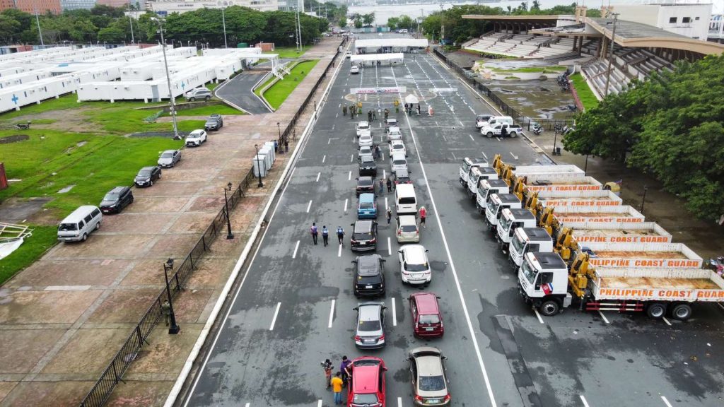 cars queuing at manila’s drive thru vaccination site