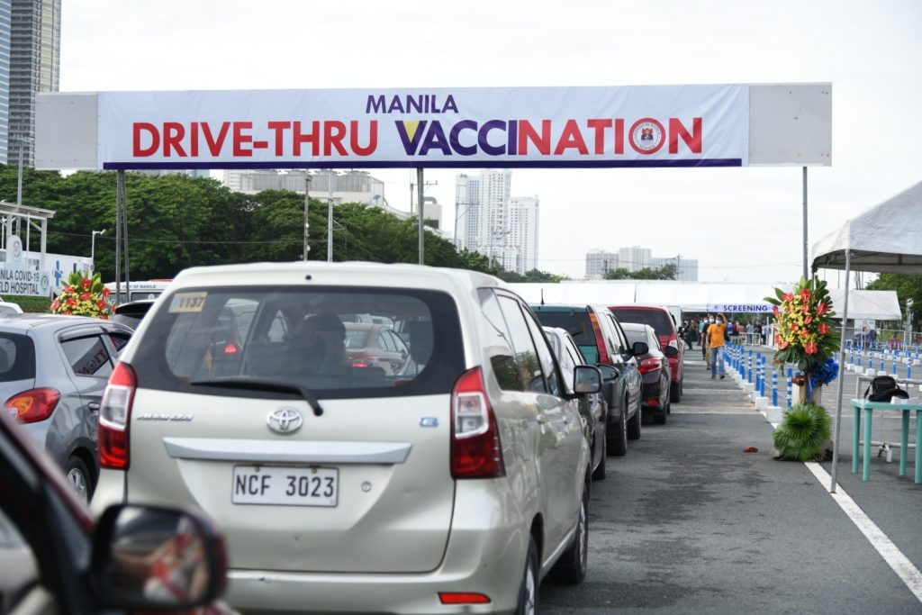cars queuing at manila’s drive thru vaccination site