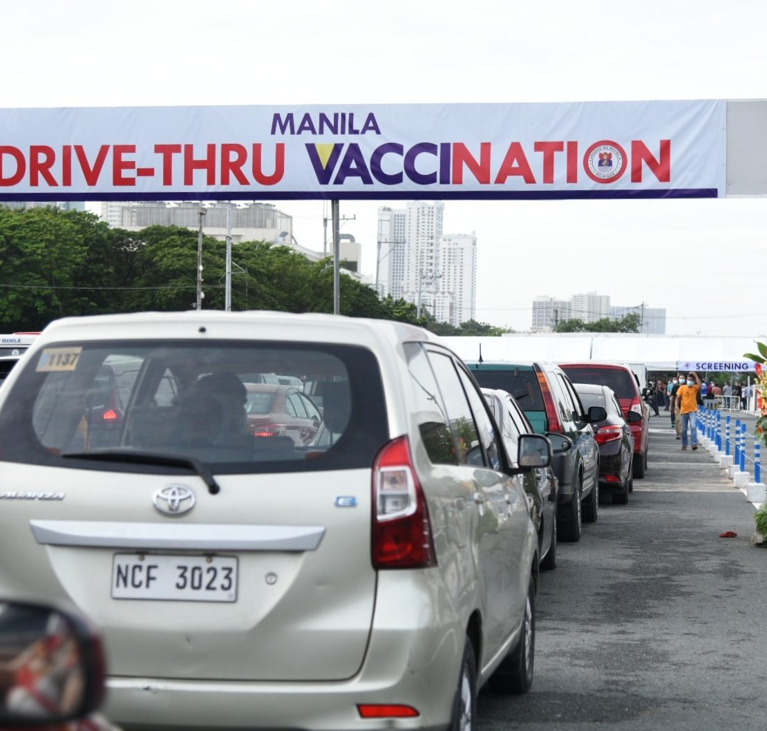 cars queuing at manila’s drive thru vaccination site