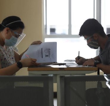 woman and man filling out forms in a government office