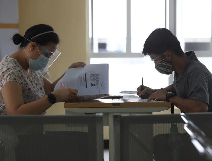 woman and man filling out forms in a government office