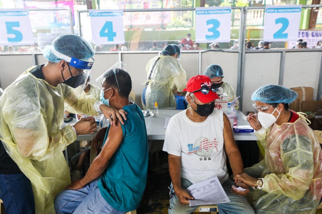 two men being vaccinated in san pedro, laguna by an initiative of the office of the vice president