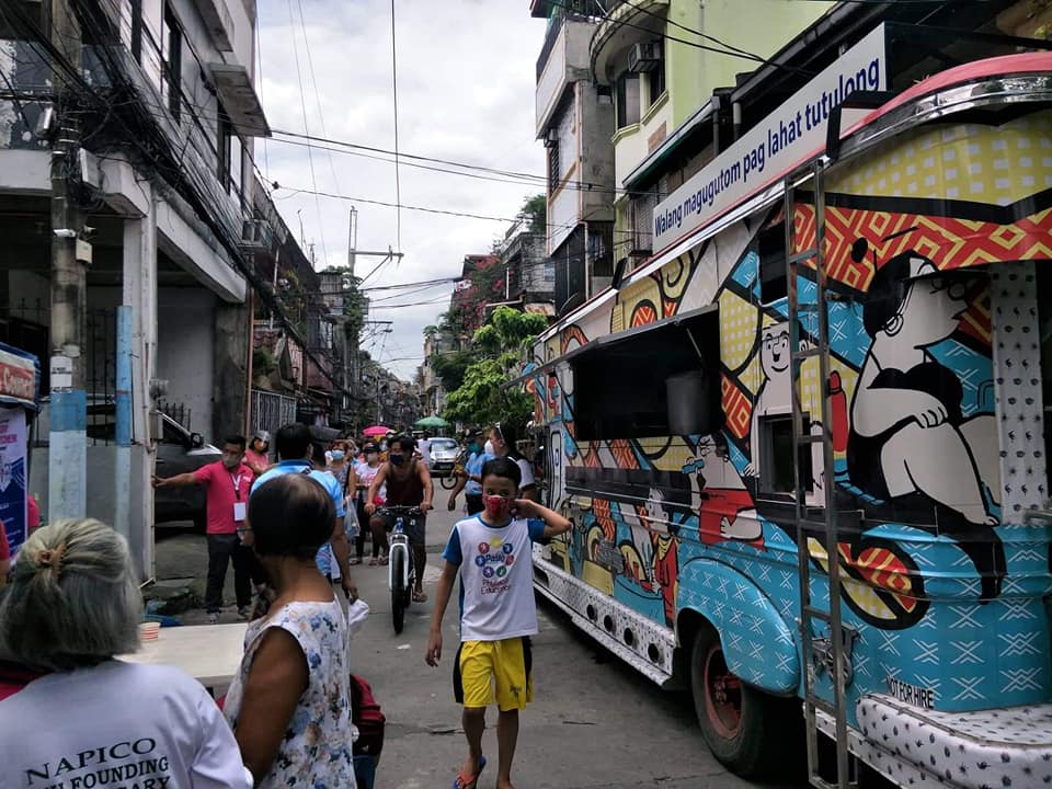 jeepney mobile kitchen parked in a community with children
