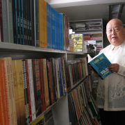 f sionil jose holding his book inside a library