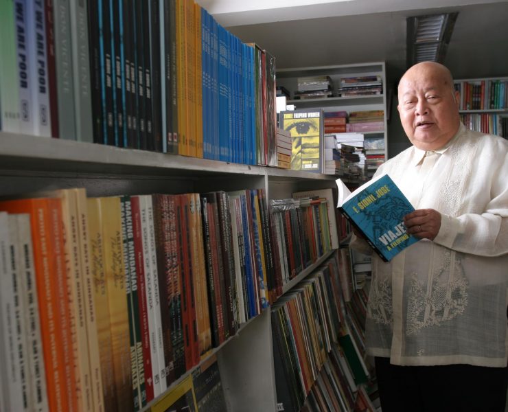 f sionil jose holding his book inside a library