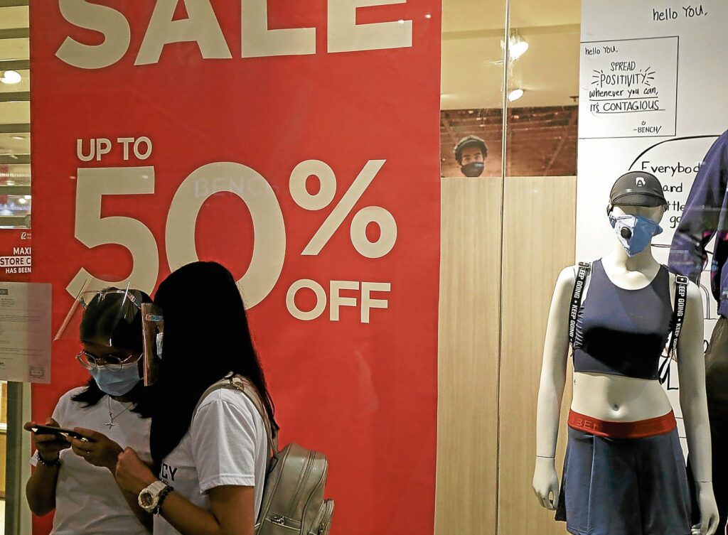 two women inside a mall wearing masks