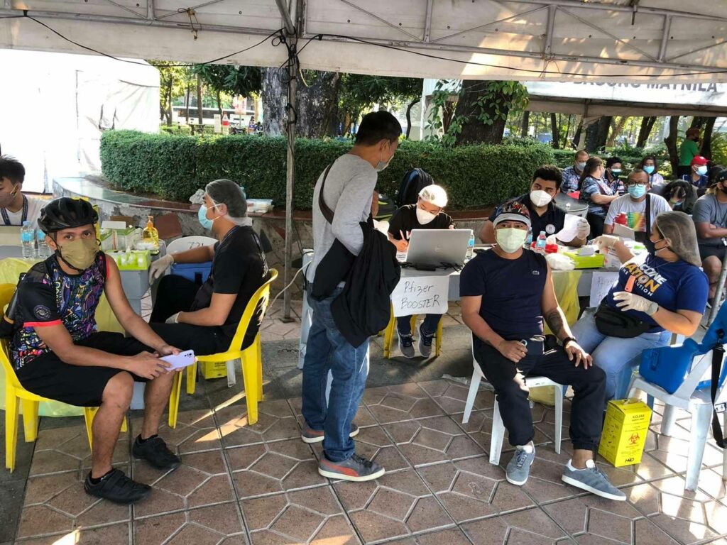 bike and motorcycle riders having their booster shots at a drive-thru in Manila