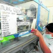 a woman buying over-the-counter medicine at a pharmacy