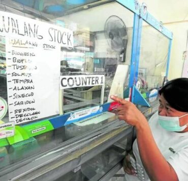 a woman buying over-the-counter medicine at a pharmacy