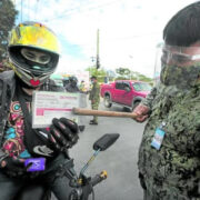 a motorist presenting his vaccination card to a police officer at a checkpoint