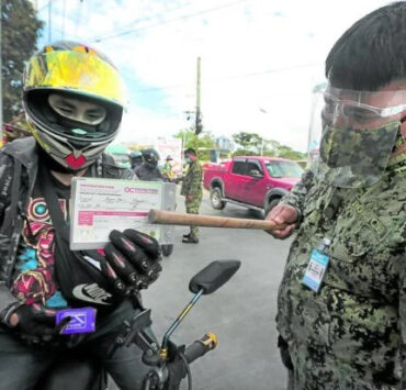 a motorist presenting his vaccination card to a police officer at a checkpoint