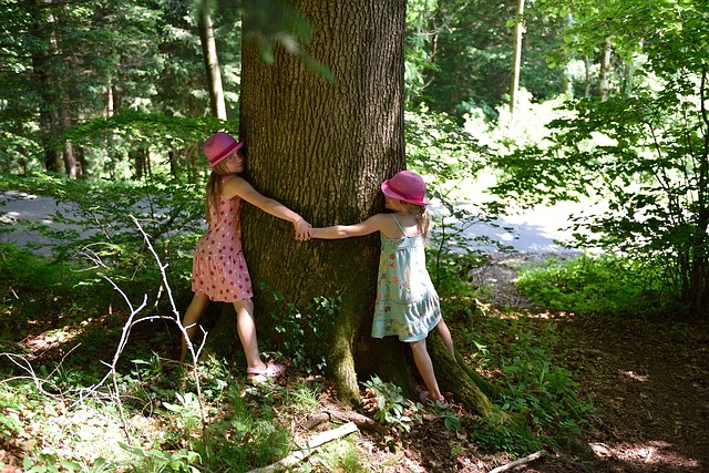 two girls hugging a tree
