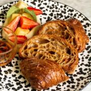 croissant french toast with pastry cream and fruits on a speckled plate