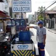employee of marikina cemo empties a bottle of used oil into a barrel for collection