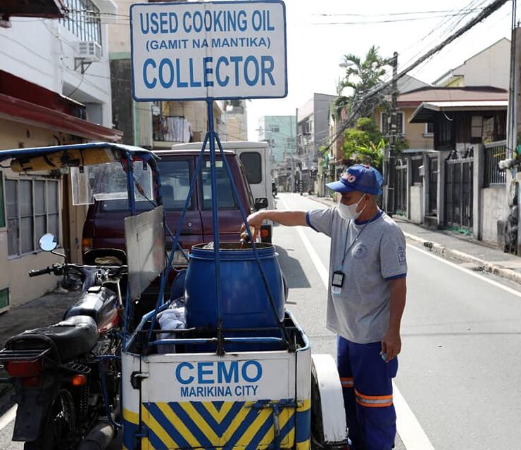 employee of marikina cemo empties a bottle of used oil into a barrel for collection