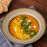 corn carrot soup on a bowl and a side of pita chips